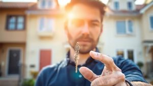 Cheie de casă cu case în fundal.